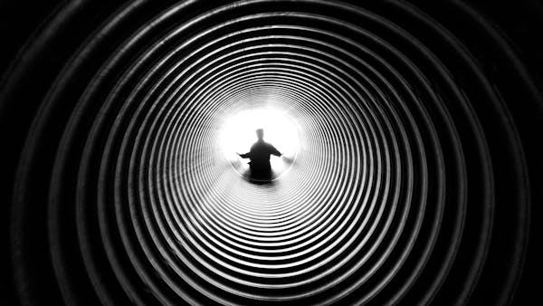 black and white photo of man in black hole